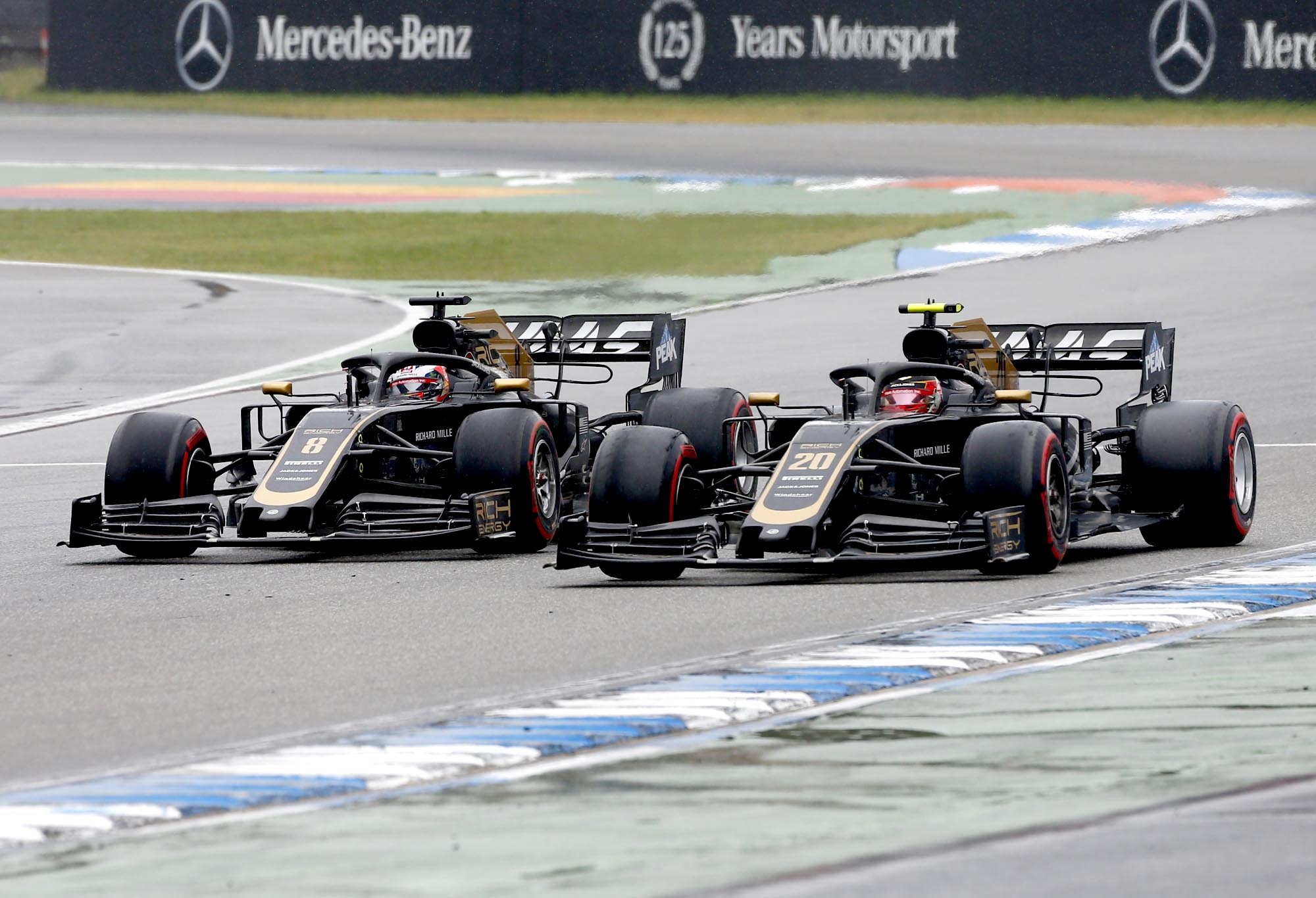 Romain Grosjean and Kevin Magnussen race wheel-to-wheel on track at Hockenheim.